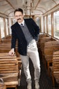 man with a mustache in a suit with glasses posing in an old train wagon or carriage Royalty Free Stock Photo