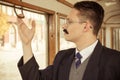 man with a mustache in a suit with glasses posing in an old train wagon or carriage and trying to open window Royalty Free Stock Photo