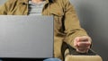 Man freelancer sits in soft armchair working on laptop