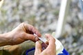 A man in nature sits and twists a cigarette with his hands Royalty Free Stock Photo