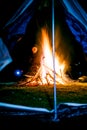 Man near huge camp fire holding lantern Royalty Free Stock Photo