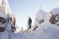 Man near rocks. Snow covered spruces. Mountain Zyuratkul, winter