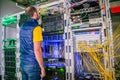 The man is near the server racks of the data center. Technician will check the work of computer communication. The system Royalty Free Stock Photo