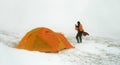 Man near tent in snow blizzard