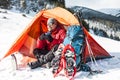 A man near a tent in the winter.