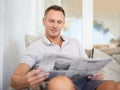 Man, newspaper and happy for reading on sofa to relax with reading, knowledge and information on patio. Person Royalty Free Stock Photo