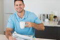 Man with newspaper holding coffee cup at table Royalty Free Stock Photo