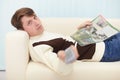 Man with newspaper and remote control Royalty Free Stock Photo