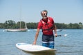 Man next to stand-up paddle board on lake Royalty Free Stock Photo