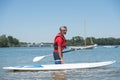 Man next to stand-up paddle board on lake Royalty Free Stock Photo