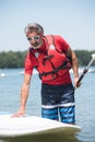 Man next to stand-up paddle board on lake Royalty Free Stock Photo