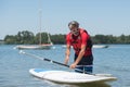 Man next to stand-up paddle board on lake Royalty Free Stock Photo