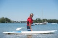 Man next to stand-up paddle board on lake Royalty Free Stock Photo