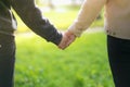 A man next to woman, guy and a girl are standing close, touching each other, holding hands. The concept of first teenage love. Boy