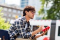 Man with notebook or diary writing on city street