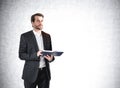 Man with notebook in hands on grey background, mockup empty wall Royalty Free Stock Photo