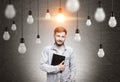 Man with notebook and many light bulbs Royalty Free Stock Photo