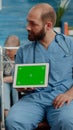 Man nurse and old patient looking at green screen on tablet Royalty Free Stock Photo