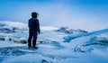 Man observes the ice wasteland of Iceland in winter