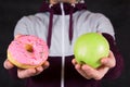 Man offering apple and donut as concept of healty lifestyle Royalty Free Stock Photo