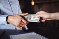 Man offering batch of hundred dollar bills. Hands close up. Venality, bribe, corruption concept. Hand giving money - Royalty Free Stock Photo