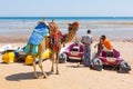 Man offering camel ride on the beach of Hurghada