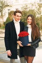 Man offering flower box of red roses to beautiful young woman Royalty Free Stock Photo
