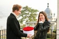 Man offering flower box of red roses to beautiful young woman Royalty Free Stock Photo