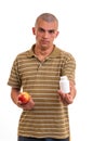Man offering pill in one hand and apple in another. Royalty Free Stock Photo
