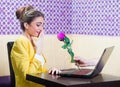 Man offering a rose to a beautiful woman over laptop screen