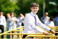 Man in office clothes with tie overcomes sports equipment outdoors.