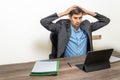 man in the office with his arms above his head with a surprised expression, looking at the computer screen, a human error