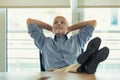 Man in office relaxes with arms crossed behind his head and feet Royalty Free Stock Photo