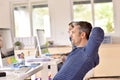 Man in office relaxing with arms behind head Royalty Free Stock Photo