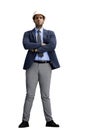 A man in an office suit with a helmet on a White background crossed his arms in full height Royalty Free Stock Photo