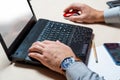 A man in the office typing on a laptop keyboard. Businessman at work. Hands close up Royalty Free Stock Photo