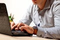 A man in the office typing on a laptop keyboard. Businessman at work