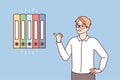 Man office worker points finger at multicolored folders for documents