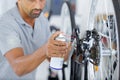 man oiling bicycle chain and gear with oil spray Royalty Free Stock Photo