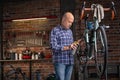 Man oiling the chain on a bicycle in a workshop