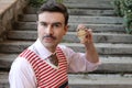 Man with old fashioned elegant look holding wooden spinning top