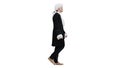 Man in old-fashioned laced frock coat and white wig walking in a mannered way looking at camera on white background.