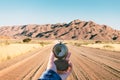 Man with old metal compass in hand on gravel road in Namibia