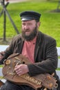 A man with an old Russian musical instrument in hand,