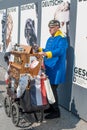 A man, in the old uniform of a German soldier, playing the barrel organ on the main street of Berlin