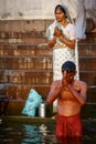 Man and old woman praying at the Ganges