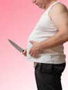 A man with one hand holds the fat fold on his big belly, and in Royalty Free Stock Photo