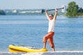 Man with open arms is standing next to SUP board Royalty Free Stock Photo