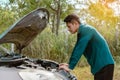 Man open car hood for repair as maintenance service. Man trying to check a car engine, looking inside open bonnet. Car broken conc Royalty Free Stock Photo