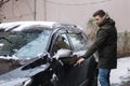 Man open door into the car and try to sit. Winte outdoor Royalty Free Stock Photo